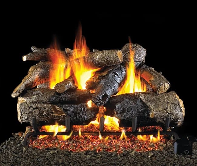 Vented gas log set with charred oak ceramic logs burning over a glowing ember bed inside a fireplace